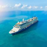 A large cruise ship sailing on a calm blue ocean