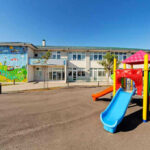 Somali Gang MOCKS Taxpayers During BILLION-Dollar Fraud Colorful playground slide in front of a building.