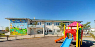 Colorful playground slide in front of a building.