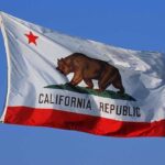 California state flag featuring a bear and a red star against a blue sky