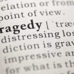 Close-up of the word 'Tragedy' in a dictionary with its definition