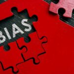 Red puzzle pieces forming a head silhouette with the word 'BIAS' inside