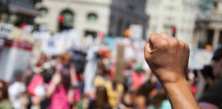 Raised fist in front of a crowd.