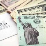 Trump’s $2,000 Rebate Awaits Congress Approval A tax refund check from the IRS alongside various denominations of cash