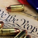 SEISMIC Gun Rights Victory Stuns Woke State Close-up of bullets surrounding a historical document with the phrase We the People