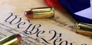 Close-up of bullets surrounding a historical document with the phrase We the People