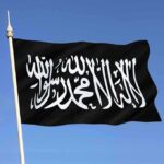 Black flag featuring Arabic script against a blue sky