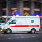 Cook Dunks Head Into Deep Fryer In HORRIFIC Suicide! Ambulance driving on urban street with lights flashing.