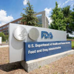 Trump FIRES Controversial FDA Head After One Year! FDA building sign with blue sky background.