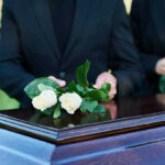 Long-Time Congressman Passes Away Aged 86! People placing white roses on a casket.