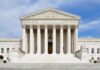 SCOTUS Judge Targeted At Home! Front view of the Supreme Court building with large columns and steps under a blue sky