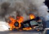 Wall Street EXPLOSION – Dozens Injured! An overturned car engulfed in flames and smoke on a city street