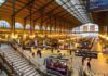 Train Station Terror ATTACK – Kids Targeted! Interior view of a busy train station with large windows and a staircase