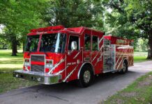 A red fire truck parked in a green park