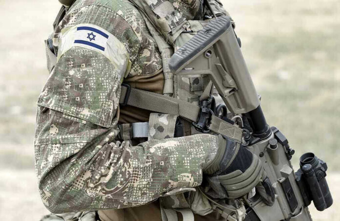 1917131027 Soldier in camouflage gear with Israeli flag patch.