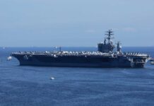 A large aircraft carrier sailing in the ocean