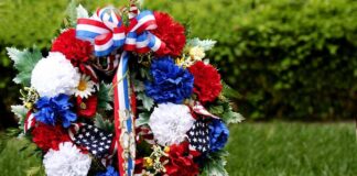 A patriotic memorial wreath adorned with red, white, and blue flowers