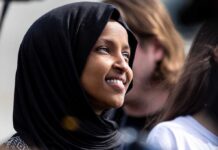 Ilhan Omar Broke – Millionaire Mirage VANISHES! A woman wearing a black hijab smiling at an outdoor event