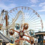 10 Senators BOYCOTT State Event! Colorful amusement park scene featuring a ferris wheel and carousel