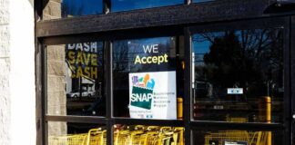 Store entrance with yellow shopping carts behind glass doors