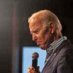 elderly man holding a microphone on stage