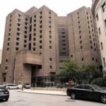 Brutalist high-rise detention facility on a city street