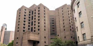 Brutalist high-rise detention facility on a city street