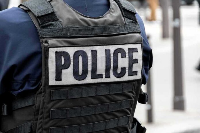 Police officer wearing a tactical vest with large POLICE patch