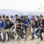 Woke-State Giving Muslims Priority for TOP Jobs Group of people walking past barbed wire