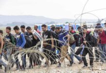 Woke-State Giving Muslims Priority for TOP Jobs Group of people walking past barbed wire