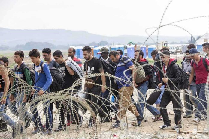 Group of people walking past barbed wire