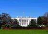 The White House facade with flag and gardens