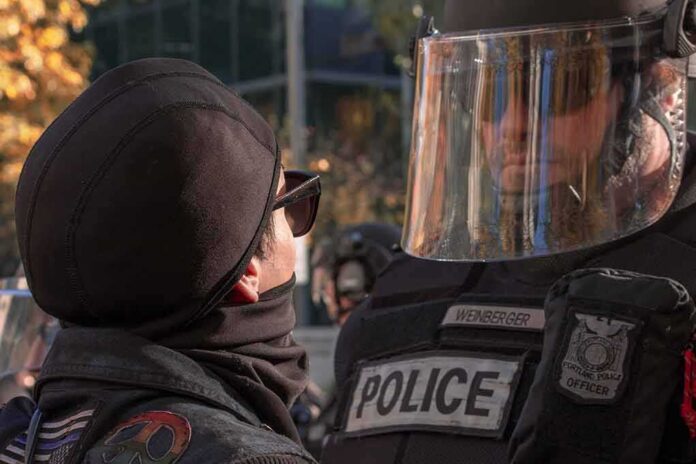 shutterstock_1234913755 protester faces police officer in riot gear