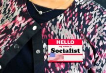 Person wearing patterned cardigan with a name badge on chest