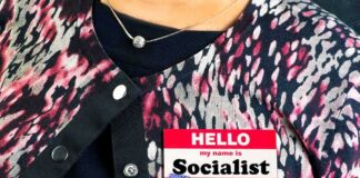Person wearing patterned cardigan with a name badge on chest