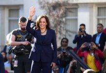 woman in navy suit waving at outdoor event