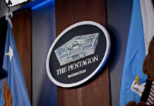 Pentagon Purge – Hegseth Cuts Generals And Admirals The Pentagon emblem between two flags.