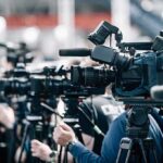 Fireball Engine Stuns American Airlines Takeoff Broadcast cameras on tripods at a press event
