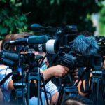 13 Frat Bros ARRESTED in Trafficking Sting Op TV news cameras crowding together at an outdoor event