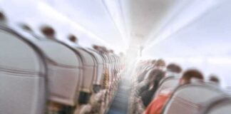 Airplane cabin aisle with blurred passengers and seats