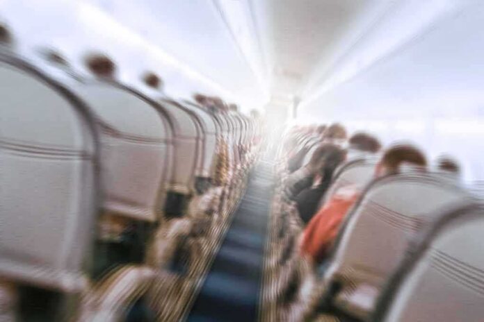 Airplane cabin aisle with blurred passengers and seats