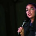 Dem Candidate SCREAMS During Concession Speech After Failed Comeback Woman speaking into a microphone on stage