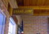 Grand jury sign in a brick-walled hallway