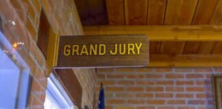 Grand jury sign in a brick-walled hallway