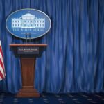 Trump Launches TV Channel Amid Media Blackout White House press briefing podium with U.S. flag and blue curtain