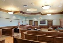 Woman Arrested Outside Lindsay Clancy Courthouse Empty courtroom with wooden benches and judge's bench