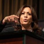 Woman speaking at a podium and gesturing with her hand