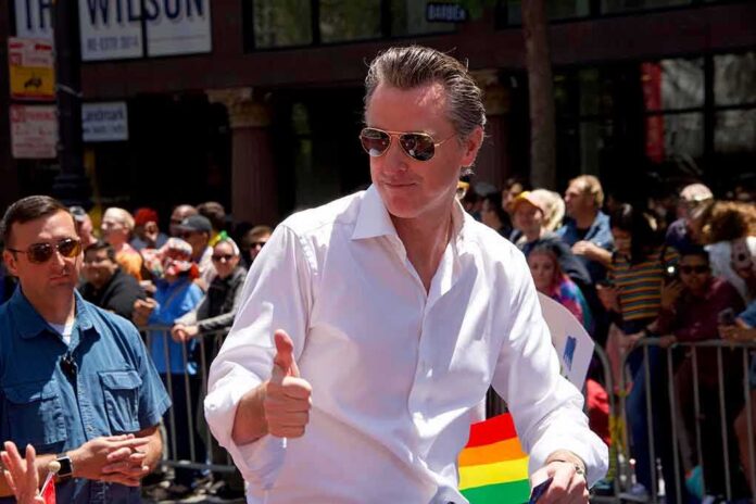 shutterstock_1442483177 Gavin Newsom gives a thumbs-up at a parade; Teddy Williams stands nearby in a crowd