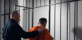 Officer escorting inmate into jail cell