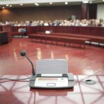 Hegseth INFURIATES Congress With Bizarre Testimony Conference microphone on a podium in a courtroom